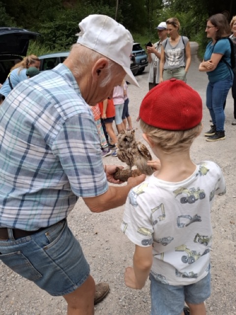 Ein Mann und ein Kind halten einen ausgestopften Vogel.