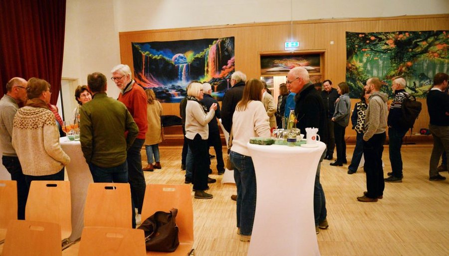 Besucher*innen stehen im lockeren Gespräch rund um Stehtische in der Friesenhalle