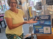Zu sehen ist Sabine Canditt neben einer Handy-Sammelbox der Deutschen Umwelthilfe